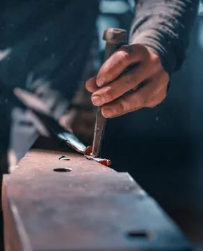 Close-up of the hands of a blacksmith during artistic forging. Stock Photos