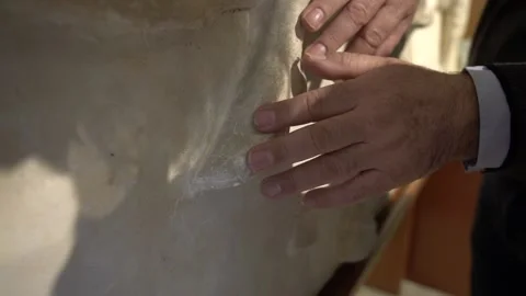 Close up of hands of blind man touching a copy of the parthenon marbles at t Stock Footage 140991703