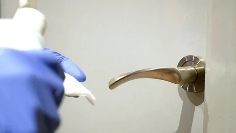 Close up of hands with blue gloves cleaning a door handle with disinfectant. Stock Footage 127638951