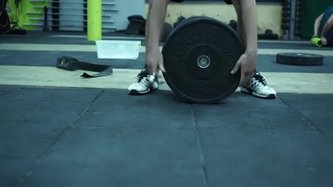 Close-up on Hands: Bodybuilder Puts Additional Weights on a Barbell. Stock Footage 131029557