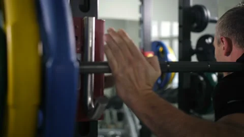 Close-up. Hands of the bodybuilder who puts the barbell on the hook 4K Slow Mo Video stock 100257946