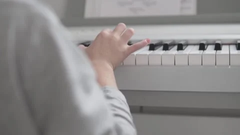 Close-up, the hands of a boy playing a light electronic piano on notes Stock Footage 145414337