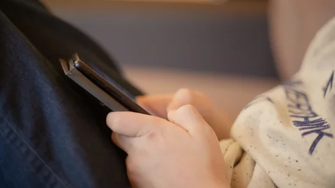 Close up of the hands of a boy who plays phone Stock Footage 127978088