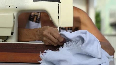 Close up hands of brazilian elderly woman using sewing machine Stock Footage
