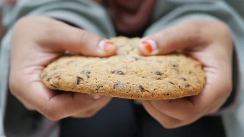 Close up of hands breaking apart a chocolate chip cookie showing texture an.. Stock Footage 332626818