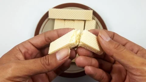 Close-up hands breaking crispy rectangular wafer cookies motion clip Stock Footage 329838177