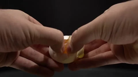 Close-up of Hands Breaking Egg on Black Background Stock Footage 147872502