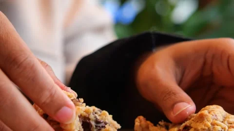Close up hands breaking warm homemade chocolate chip cookie in half reveali.. Stock Footage 332144066