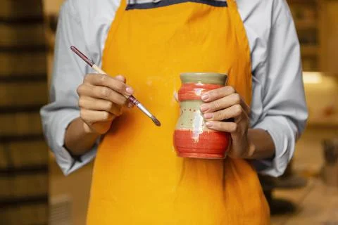 Close up hands with brush and clay pot Stock Photos