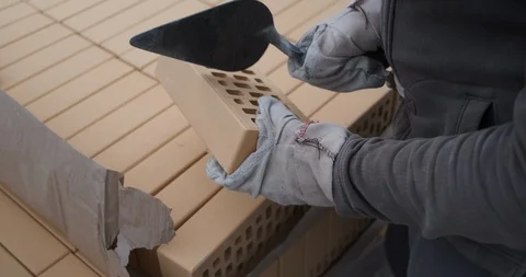 Close-up hands of builder with brick, one blow brick is broken into two parts Stock Footage 116794949