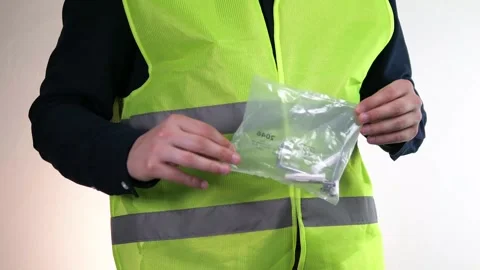 Close-up of hands of builder or handyman with transparent packaging of dowels Stock Footage 313866801
