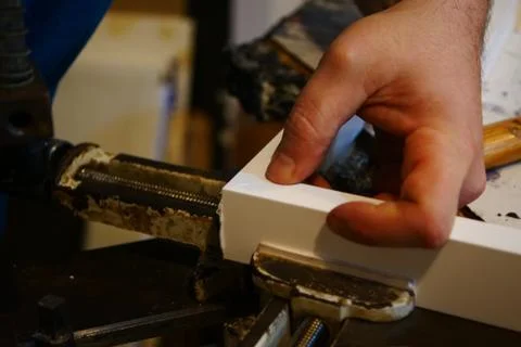 Close-up of hands building a [picture frame with dramatic lighting Stock Photos