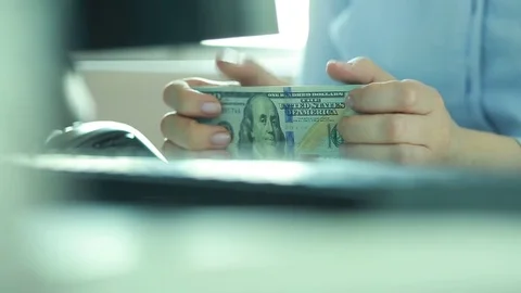 Close-up of the hands of a business woman with a bundle of dollars.  Stock Footage 75048341