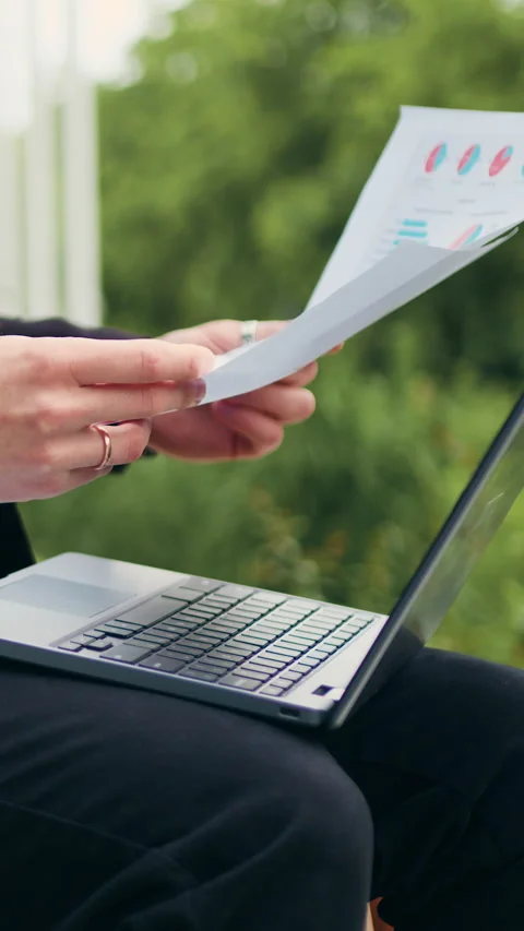 Close up hands. Businessman reading documents with financial data and using lapt Stock Footage 330257396