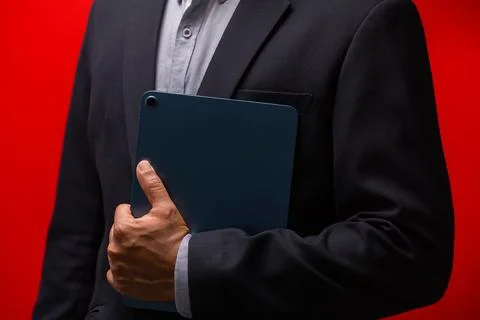 Close up hands of businessman using digital tablet device isolated on red b.. Stock Photos