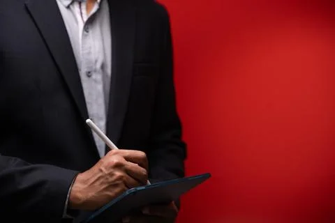 Close up hands of businessman using digital tablet device isolated on red b.. Stock Photos