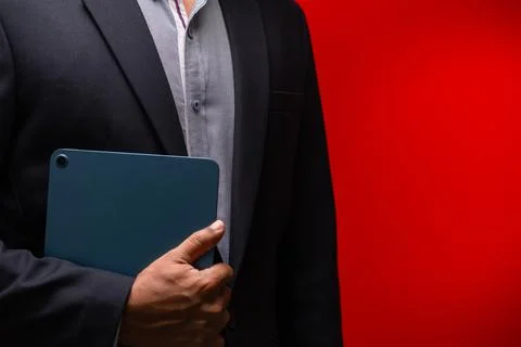 Close up hands of businessman using digital tablet device isolated on red b.. Foto stock