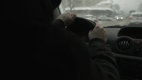 Close up hands of car driver while holding steering wheel, snow falling blurred. Stock Footage 87684988