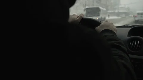 Close up hands of car driver while holding steering wheel, snow falls blurred. Stock Footage 87751971