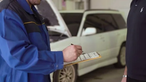 Close up of a hands of car mechanic taking car keys and shaking hads with client Video stock 74609571