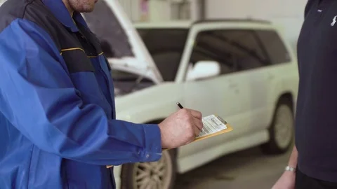 Close up of a hands of car mechanic taking car keys and shaking hads with client Stock Footage 74612653
