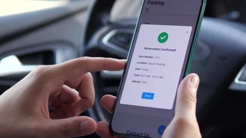 Close-up of hands in car receiving parking reservation confirmation on Stock Footage 315029914