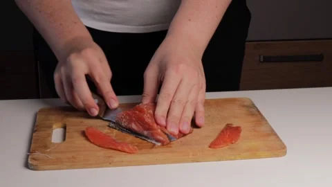 Close-up of hands carefully cutting fresh red fish fillet into thin slices .. Stock Footage 320954589