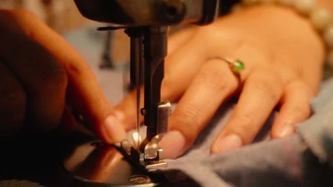 Close-up of hands carefully guiding gray fabric along the edge under a sewi.. Stock-Footage 342582828