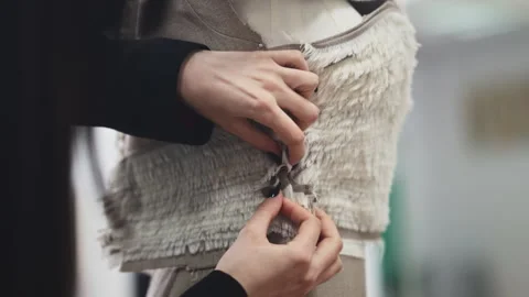 Close up of hands carefully lifting and aligning layered fabric samples, Stock Footage 335869720