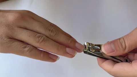 Close Up Of Hands Carefully Trimming Fingernails With Nail Clippers On A Wh.. Stock Footage 313542593