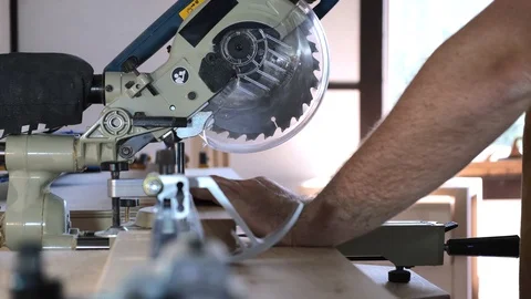 Close-up. Hands of a carpenter lower a circular saw on a wooden block. Slow Stock Footage 113996612