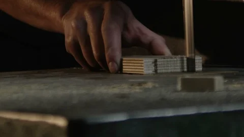 Close up on hands of carpenter who cuts a piece of wood with a band saw Stock Footage 88812069