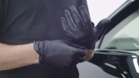 Close-up of the hands of a Caucasian man master who pull on and adjust black Stock Footage 248423148