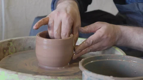 Close up hands of a ceramist using potter's wheel to make a cup Stock Footage 240635902