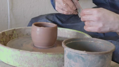 Close up hands of a ceramist using potter's wheel to make a cup Stock Footage 240635974