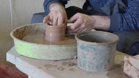 Close up hands of a ceramist using potter's wheel to make a cup Stock Footage 240636194