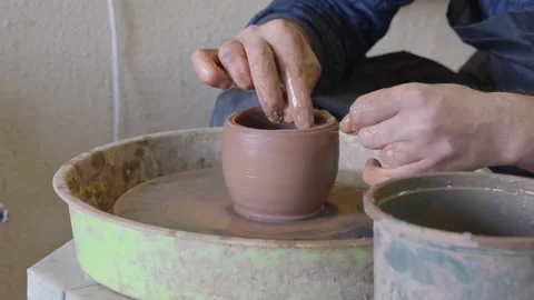 Close up hands of a ceramist using potter's wheel to make a cup Stock Footage 240636216