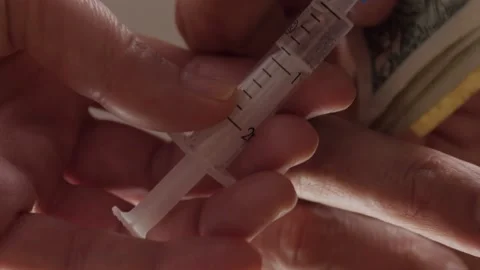Close-up of hands changing banknotes for a syringe with a substance. Stock Footage 150060567