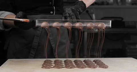 Close-up - hands of the chef, in black gloves, beautifully pouring out chocolate Video stock 165455424