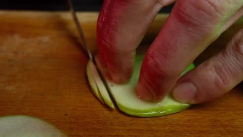 Close up hands of chef cook cutting apple in slow motion in a dark kitchen Video stock 153206630