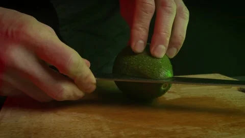 Close up hands of chef cook cutting avocado in slow motion in a dark kitchen Video stock 153206644
