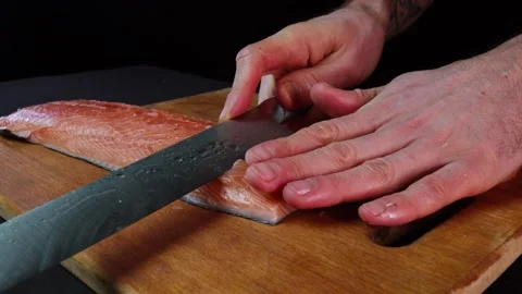 Close up hands of chef cook slicing fish in slow motion in a dark kitchen Video stock 153206778