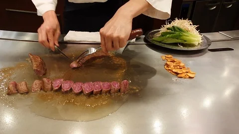 Close up hands of chef cutting medium grilled beef steak with knife Stock Footage 110907661