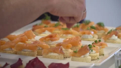 Close-up on the hands of the chef decorating a salmon with bread Stock Footage 132426536