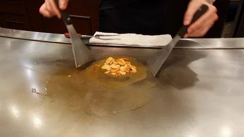 Close up hands of chef fried garlic chips(side dish of beef steak)on steel pan Stock Footage 110907637