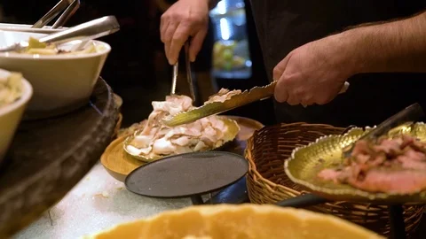 Close up hands of chef laying out the meats at salad bar Stockbeeldmateriaal 104018033