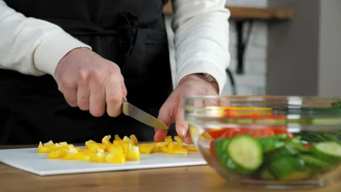 Close up hands chef man in apron sliced fresh yellow pepper on board in kitchen Stock Footage 147217930
