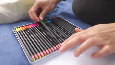 A close-up of hands choosing a colored pencil from a set Stock Footage 264881020