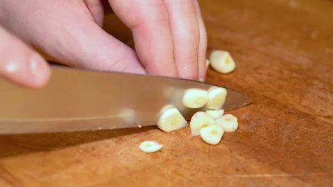 Close-up of hands chopping garlic on a cutting board Stock Footage 247830988