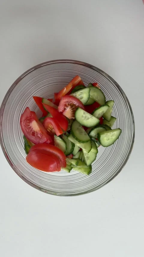 A close-up of hands chopping vegetables in a glass bowl. Video stock 340526528